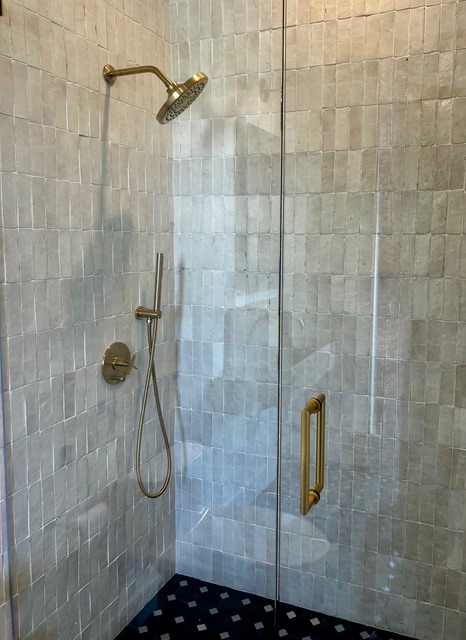 Custom walk-in shower with gold fixtures and zellige tile by So-Cal Plumbing